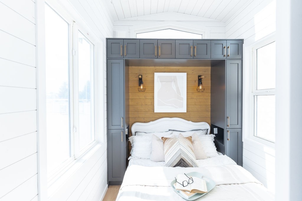 Built in cabinets around main bed on tiny house on wheels